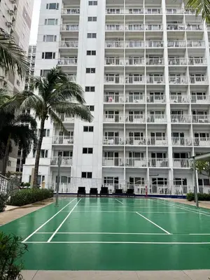 a tennis court in front of a large building at 2br shore residences staycation in Manila