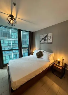 a bedroom with a bed and a large window at One Uptown Stylish Retro Suite in Manila
