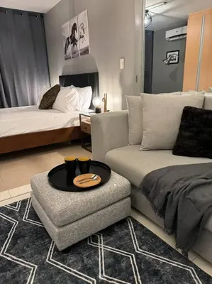 a living room with a couch and a bed at One Uptown Stylish Retro Suite in Manila