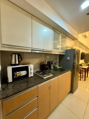a kitchen with a microwave and a counter top at One Uptown Stylish Retro Suite in Manila