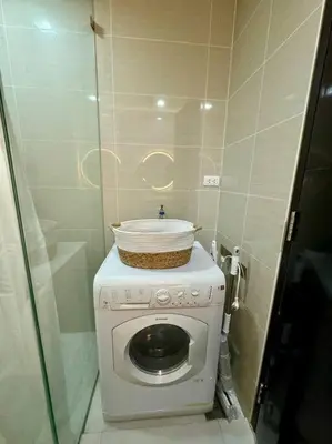 a small bathroom with a washing machine with a bowl on it at One Uptown Stylish Retro Suite in Manila