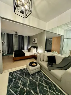 a living room with a couch and a bed at One Uptown Stylish Retro Suite in Manila