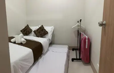a bedroom with a bed and a red suitcase at Casa Laelia in Manila
