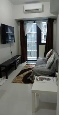 a living room with a bed and a large window at Casa Laelia in Manila