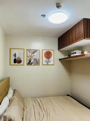 a bedroom with a bed and some pictures on the wall at HIGHLY RECOMMENDED La Nooq MNL - Cozy 1BR Skyline view in Mandaluyong in Manila