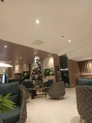 a living room with a christmas tree in a lobby at 1 Bedroom with Balcony Near MOA in Manila