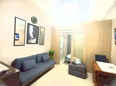 a living room with a blue couch and a table at 1 Bedroom with Balcony Near MOA in Manila