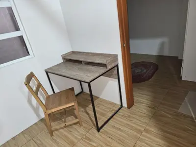 a wooden table and a chair next to a desk at 1 Bedroom Apartment in Central Makati in Manila