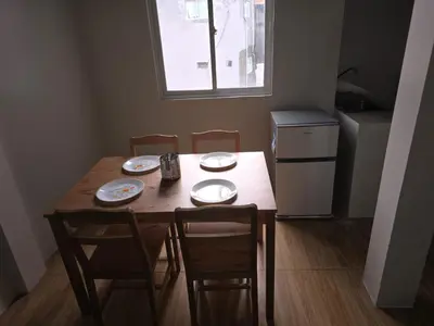 a wooden table with four chairs and a window at 1 Bedroom Apartment in Central Makati in Manila