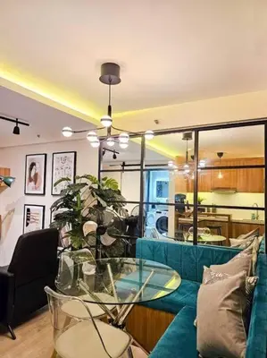 a living room with a blue couch and a glass table at Instragamable2BR near Bridgetown in Manila