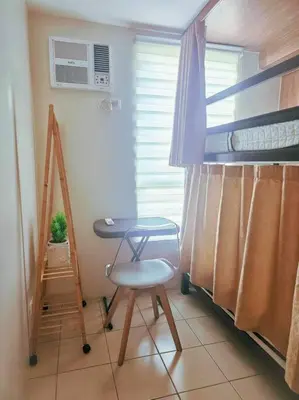 a table and a chair in a room with a window at Instragamable2BR near Bridgetown in Manila