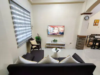 a living room with a couch and a table at Spacious Apartment near Evia Daang Hari in Manila