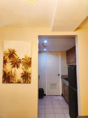 a kitchen with a painting of palm trees on the wall at 2BR 90sqm Furnished Condo Shaw Blvd, Mandaluyong in Manila