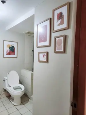 a bathroom with a toilet and pictures on the wall at 2BR 90sqm Furnished Condo Shaw Blvd, Mandaluyong in Manila
