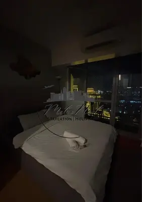 a bedroom with a bed with a view of a city at MetroNest Dettifoss in Manila