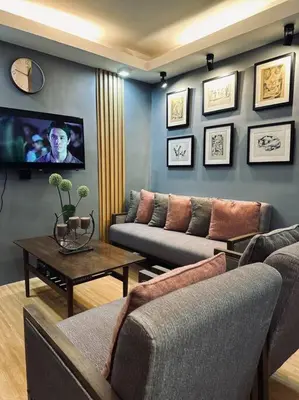 a living room with couches and a tv on the wall at H&D Suites-Memories are personal in Imus