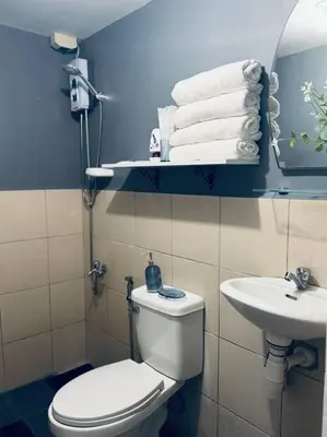 a bathroom with a white toilet and a sink at H&D Suites-Memories are personal in Imus
