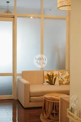 a living room with a couch and two windows at Somnus Suites at Air Residences in Manila