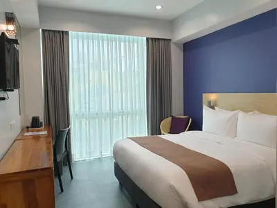 a hotel room with a bed and a large window at Leez Inn Makati in Manila