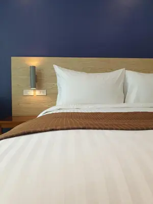 a large bed with white sheets and pillows at Leez Inn Makati in Manila