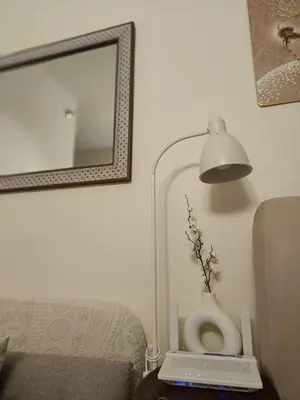 a room with a lamp and a vase on a table at Miranda's Suites by Fullerton in Puting Kahoy