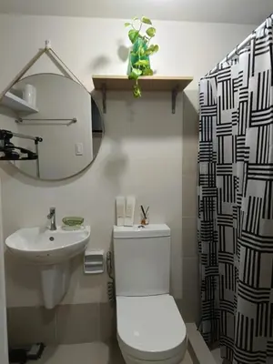 a bathroom with a toilet and a sink and a mirror at Miranda's Suites by Fullerton in Puting Kahoy