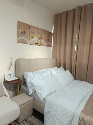 a small bedroom with a bed and a table at Miranda's Suites by Fullerton in Puting Kahoy