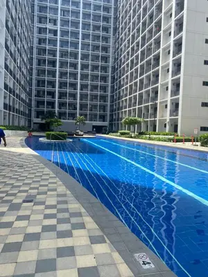 a large swimming pool in front of a tall building at Aesthetic walking distance to MOA,near NAIA AIRPORT with NETFLIX,MINIVIDEOKE,BOARDGAMES-DUXE2 in Manila