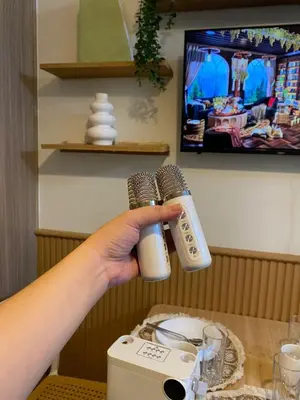 a person holding two microphones in front of a blender at Aesthetic walking distance to MOA,near NAIA AIRPORT with NETFLIX,MINIVIDEOKE,BOARDGAMES-DUXE2 in Manila