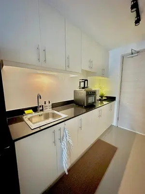 a kitchen with white cabinets and a sink at Cozy Beit 1125 in Metro Manila in Manila