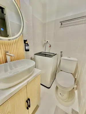 a white bathroom with a toilet and a sink at Cozy Beit 1125 in Metro Manila in Manila