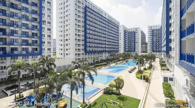 an aerial view of a pool in a city with tall buildings at Cozy Beit 1125 in Metro Manila in Manila