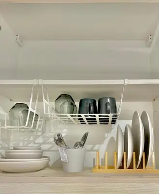a kitchen with plates and utensils on a shelf at Cozy Beit 1125 in Metro Manila in Manila