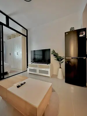 a living room with a coffee table and a black refrigerator at Cozy Beit 1125 in Metro Manila in Manila