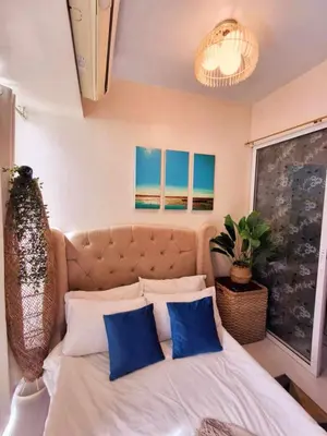 a bedroom with a large bed with blue pillows at Azure Urban Resort Parañaque Near Airport and SM Mall in Manila