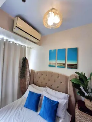 a bedroom with a bed with blue pillows at Azure Urban Resort Parañaque Near Airport and SM Mall in Manila