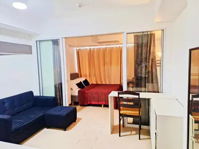 a living room with a blue couch and a bedroom at Azure Urban Resort Residences Paranaque Near Airport and Mall in Manila
