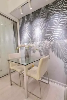 a glass table and two chairs in front of a wall at Azure Urban Resort Residences Paranaque Near Airport and Mall in Manila
