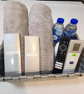 a drawer with a remote control a cell phone and water bottles at Empress Suite SMDC Hope Residences CONDOTEL with UNLIWIFI in Trece Martires