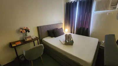 a small room with a bed with a table and a chair at Empress Suite SMDC Hope Residences CONDOTEL with UNLIWIFI in Trece Martires