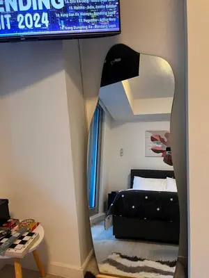 a room with a bed and a room with a mirror at Azure Urban Residences by Lyn in Manila