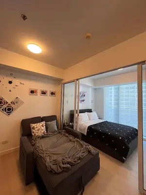 a bedroom with a bed and a couch in it at Azure Urban Residences by Lyn in Manila