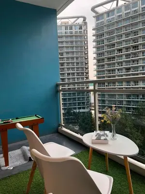 a balcony with a table and chairs and some buildings at Azure Urban Residences by Lyn in Manila