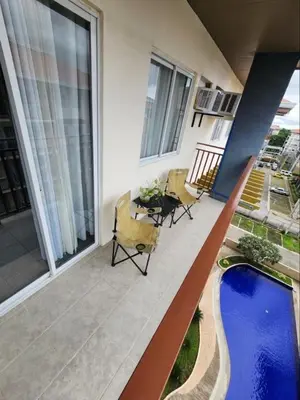 a balcony with a pool and a table and chairs at The Little Abode Nuvali - Smart Studio Unit with Balcony & free pool access in Calamba