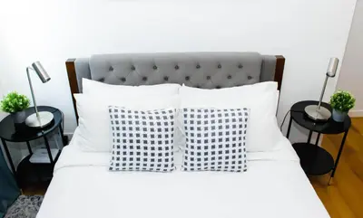 a white bed with two pillows and two tables at Stars & Sunsets Sky Views 1br Iguazu Tower in Manila