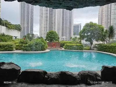 a swimming pool with tall buildings in the background at Stars & Sunsets Sky Views 1br Iguazu Tower in Manila