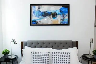 a bedroom with a bed with a picture on the wall at Stars & Sunsets Sky Views 1br Iguazu Tower in Manila