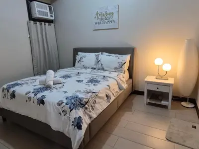 a bedroom with a bed with blue flowers on it at A&G Condotel at 101newport Near NAIA T3 in Manila