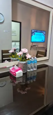 a table with bottles of water and flowers on it at A&G Condotel at 101newport Near NAIA T3 in Manila