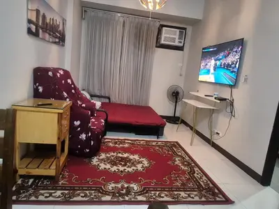 a living room with a red chair and a tv at A&G Condotel at 101newport Near NAIA T3 in Manila